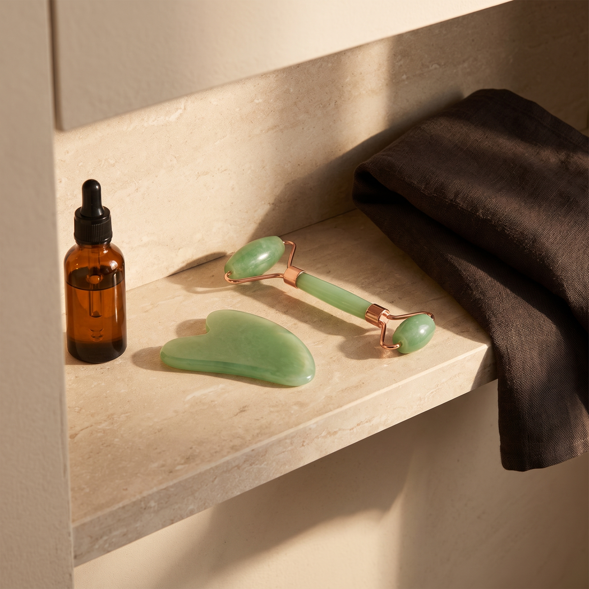 Gua sha boards on bathroom shelf with facial oil