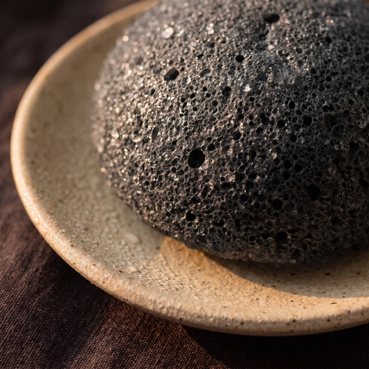 Damp black charcoal konjac sponge texture macro with water droplets