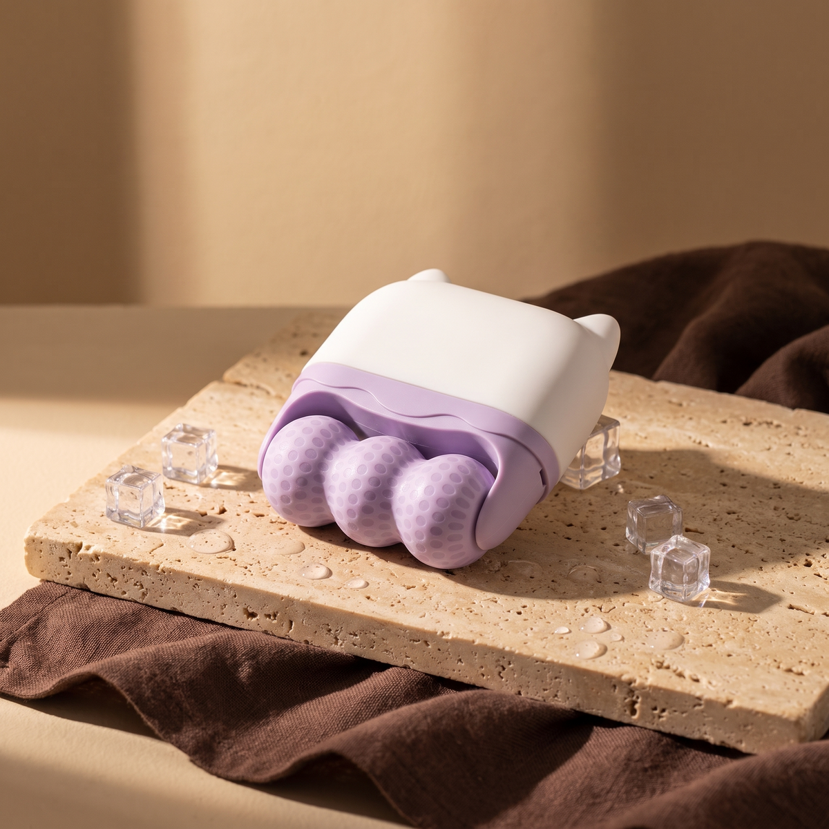 Lavender double-sided ice roller with white lid on travertine stone, ice cubes, warm morning light