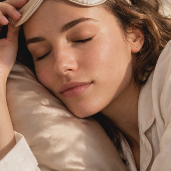 Woman in cream pajamas wearing the champagne satin eye mask, twist headband and scrunchie in bed, sleeping on the satin pillowcase, then the four pieces laid flat