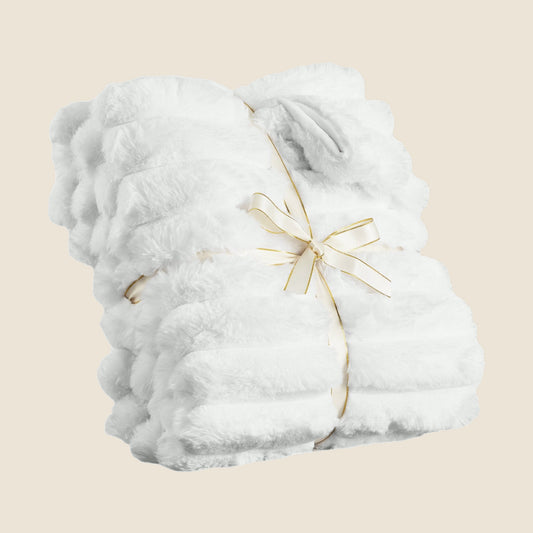 White faux-fur throw, folded and tied with a ribbon